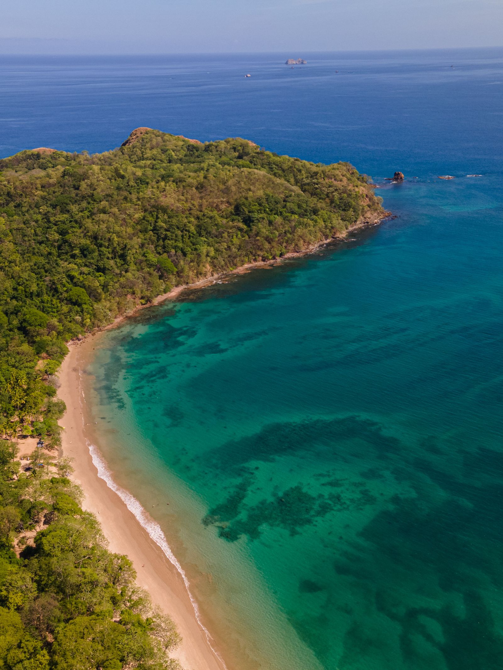 Aerial view of a secluded turquoise-water cove and green coastline in Guanacaste, Costa Rica