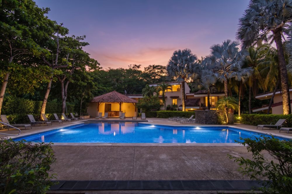 Twilight photo of a pool and villa exterior